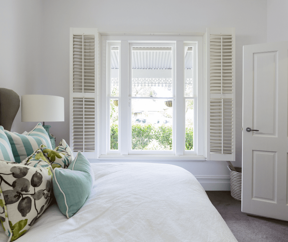 Double Bed in white bedroom with white window and louvres.